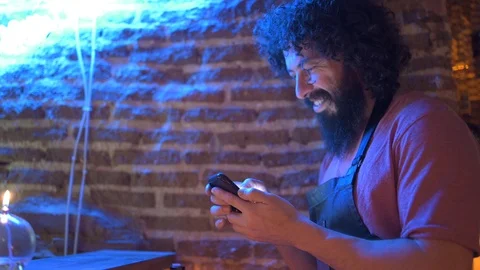 Young man, working in bar, using smartphone Stock Footage 126907701