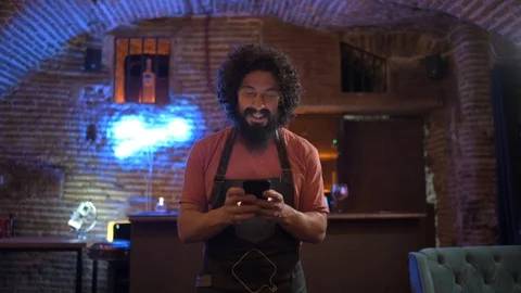 Young man, working in bar, using smartphone Stock Footage 126907711