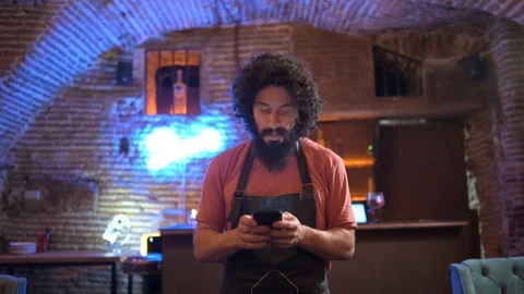 Young man, working in bar, using smartphone Stock Footage 126907733