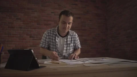 Young man working carefully attentively concentrated on small detail of paper wo Stockbeeldmateriaal 138125645