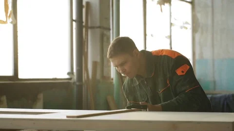 Young man working as carpenter and measuring board Stock Footage 76277668
