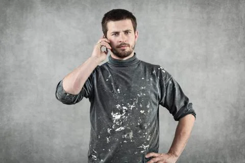 Young man in working clothes talking on the phone Stock Photos