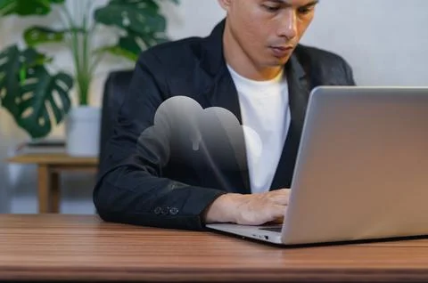 Young Man Working on Cloud Computing Laptop in Office Environment Fotos Stock