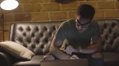 Young Man Working at Computer on Couch Video stock 208710697