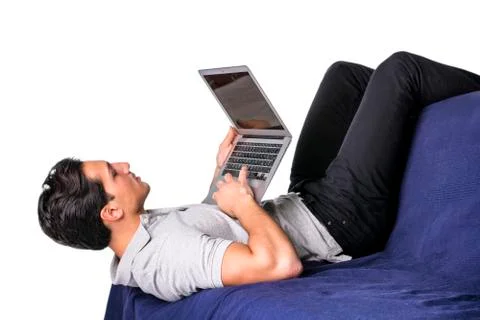 Young man working with computer on couch Stock Photos
