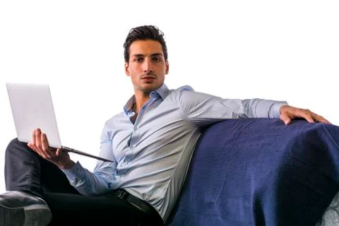 Young man working with computer on couch Stock Photos