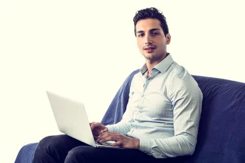 Young man working with computer on couch Stock Photos