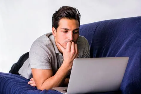 Young man working with computer on couch Stock Photos