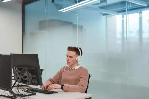 Young Man Working at Computer Desk in Office Stock Photos