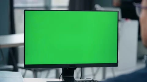 Young Man Working At Computer With Green Mock Up Screen in Office. Close Up  Stock Footage 238773220
