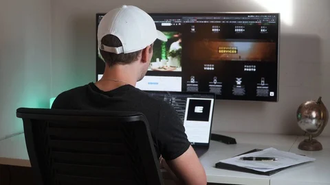 Young man working computer on his freelance photography website, 4K Stock Footage 129611433