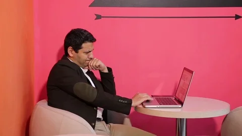 Young man is working on a computer - laptop computer showing charts and graphs.  Stock Footage 81470659