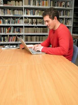 Young man working at computer in library Stock Photos