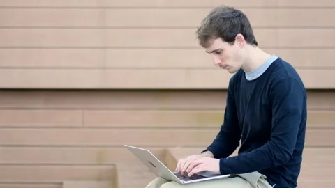 Young man working on computer outdoors Stock Footage 149823025