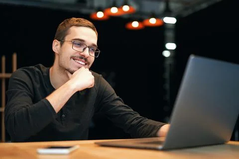 Young man working with computer, phone and tablet at the table while drinking Stock Photos