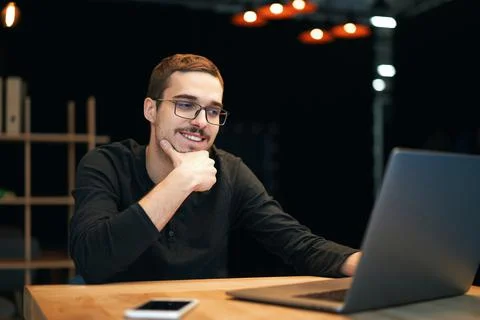 Young man working with computer, phone and tablet at the table while drinking Stock Photos
