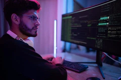 Young man working on computer programming in a modern workspace with colorf.. Stock Photos