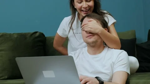 Young man that is working at the computer receiving a gift from his wife. Stock Footage 147346418