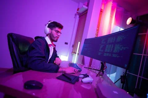 Young man working on computer at a stylish desk in a modern room with vibra.. Stock-Fotos