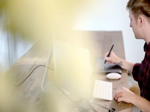 A young man working on a computer in their home. Stock Footage 82556168