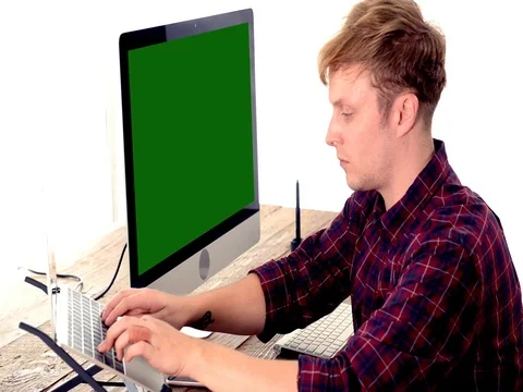 A young man working on a computer in their home. Video stock 82852870