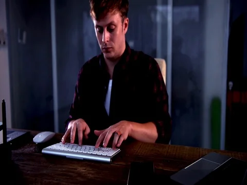 A young man working on a computer in their home. Video stock 82852882