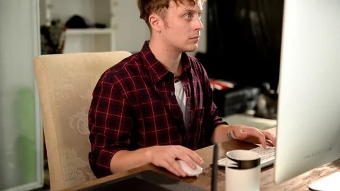 A young man working on a computer in their home. Stock Footage 82922692