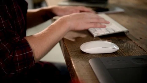 A young man working on a computer in their home. Video stock 82922698