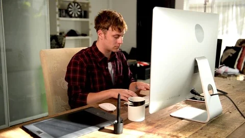 A young man working on a computer in their home. Stock Footage 82922699
