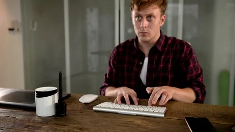A young man working on a computer in their home. Stock Footage 82922705