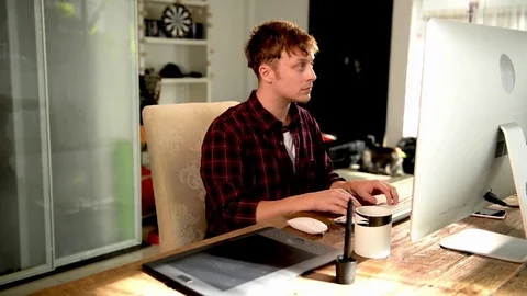 A young man working on a computer in their home. Stock Footage 82922709