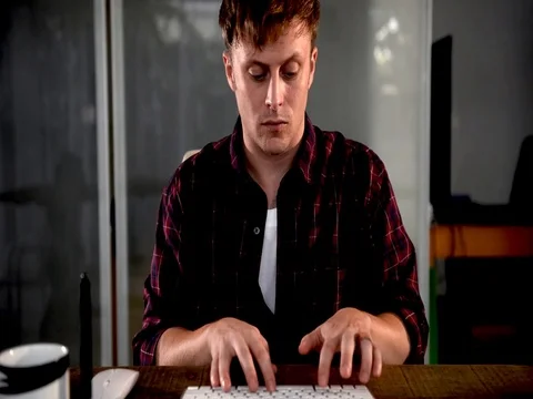 A young man working on a computer in their home. Stock Footage 82922712