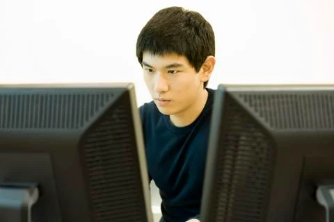 Young man working on computer with two monitors 스톡 사진