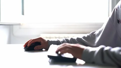 Young man working with computer using the mouse and typing on the keyboard. T Stock Footage 133232770