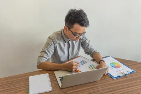 Young man working with financial document in office Stock Photos