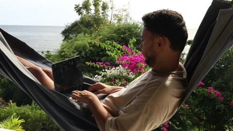 Young man working on hammock. Remote work. Working at vacation, holiday. Stock Footage 160904361