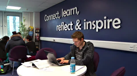 Young man working on his laptop at a college/university/learning facility Stock Footage 25859433