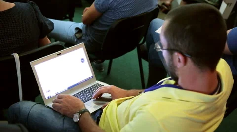 Young man working on his laptop lying on his knees, rear view Stock Footage 64998358