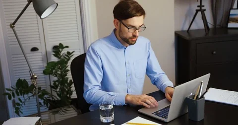Young man working on his laptop in the office. Business man typing on laptop Stock Footage 74497964