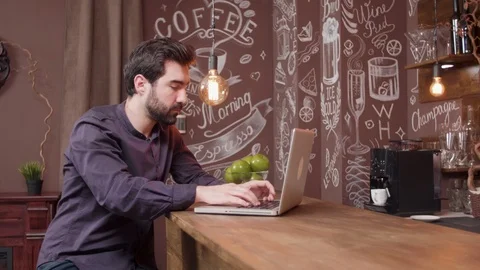 Young man working on his laptop at a bar counter Video stock 106701308