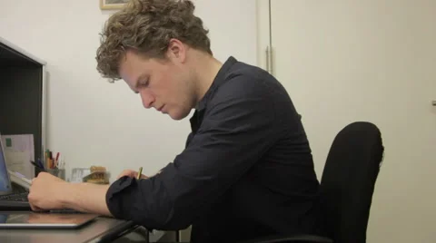 Young man working at his office desk Stock Footage 41384830