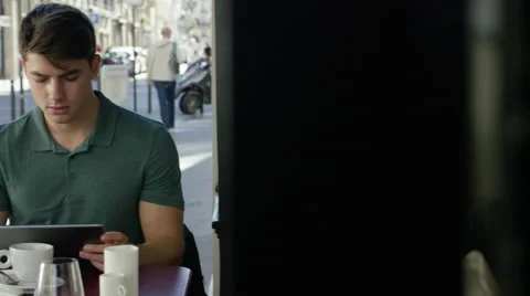Young man working on his tablet while at a local cafe. Stock Footage 63029815