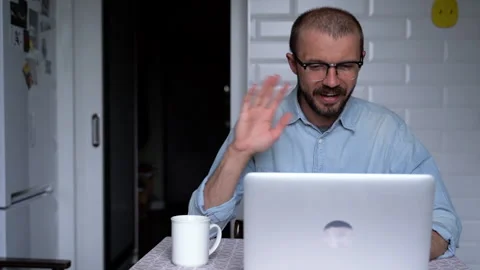 Young man is working from home and having videoconference with colleagues. Stock Footage 135980667