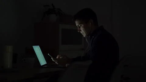 Young man working at home at night with headphones Sending an audio message. Video stock 145434518