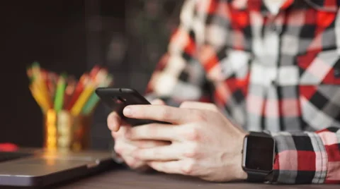 Young man working from home using smart phone and notebook computer. Stock Footage 61449526