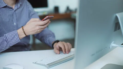 Young man working from home using smart phone and notebook computer Stock Footage 62769116