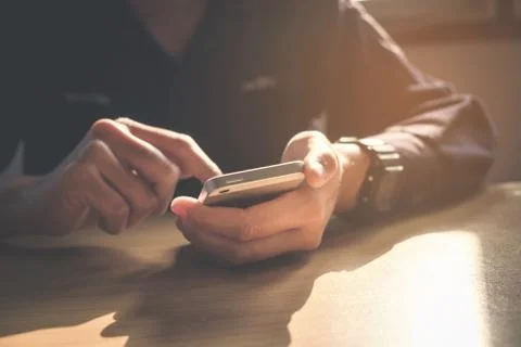 Young man working from home using smart phone Stock Photos