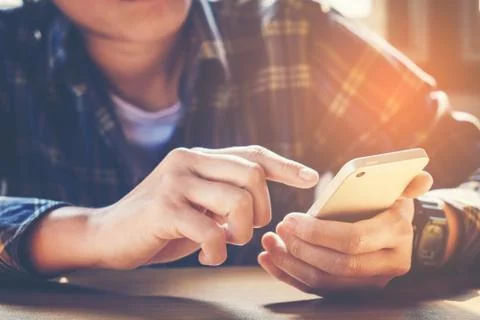 Young man working from home using smart phone Stock Photos
