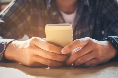 Young man working from home using smart phone Stock Photos