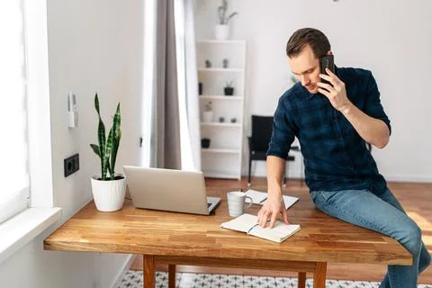 Young man working from home using laptop. Stock Photos